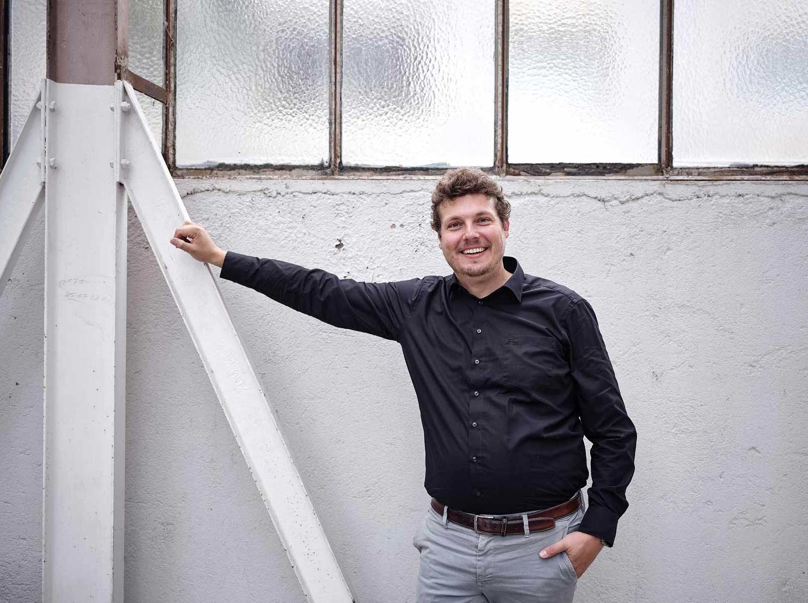 David Büchner lächelnd vor einer Backsteinwand